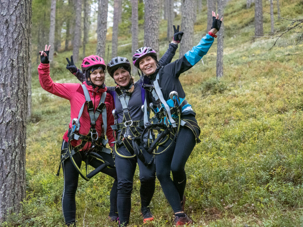 Kolme henkilöä seisoo metsässä.