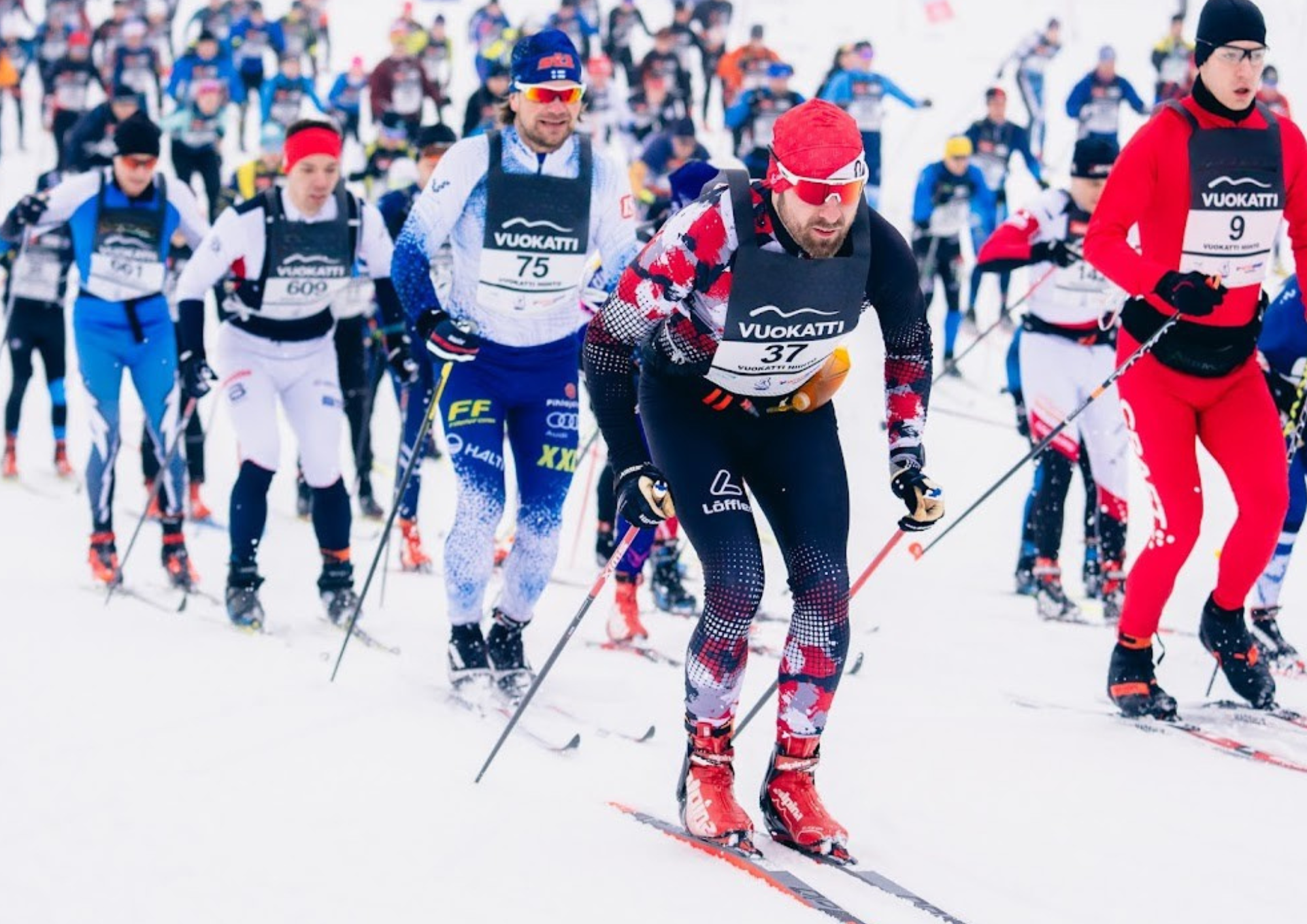 Participants of Vuokatti Hiihto glide into action as the race begins, surrounded by a stunning snowy landscape. Excitement fills the air as skiers set off to conquer the scenic trails of Vuokatti.