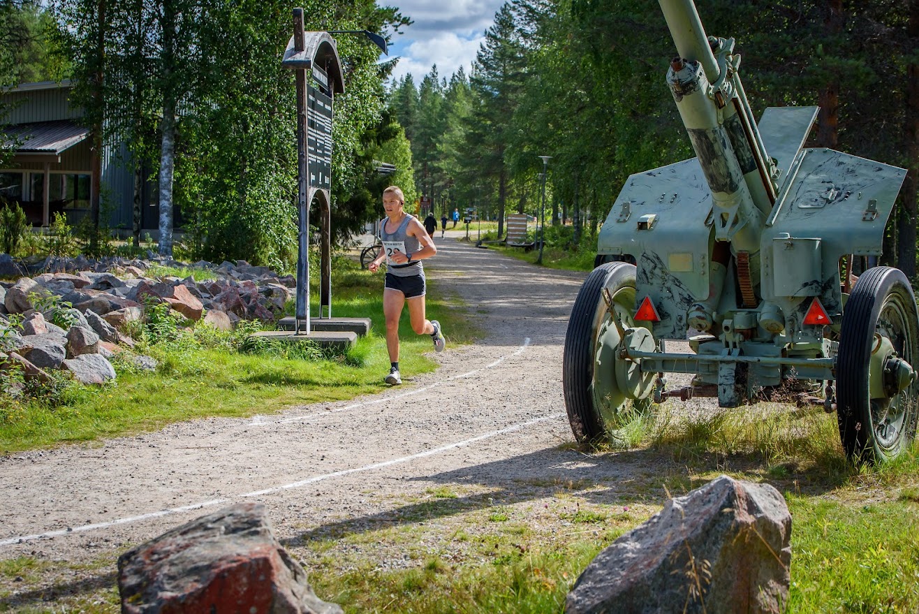 Henkilö juoksee hiekkatiellä.
