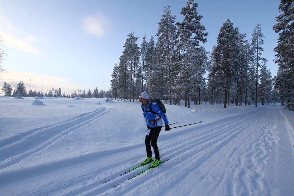 Hiihtäjä lumisessa maastossa.